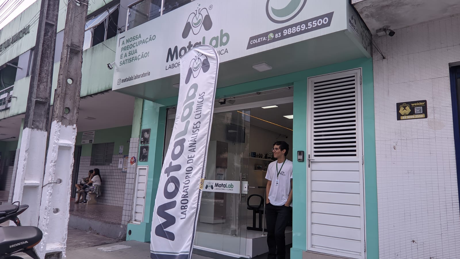 Fachada da unidade MotaLab com a equipe na entrada